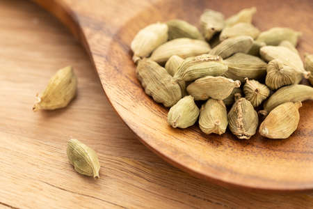 Cardamom on wooden spoon. Cooking Spices. Elettaria cardamomumの写真素材