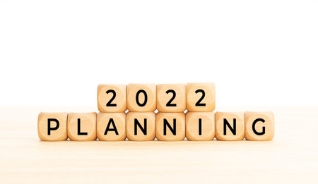 2022 Planning word in wooden blocks on table. White background. Copy space