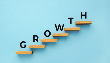 Growth word on staircase on blue background. Increasing business, success process concept. Copy...