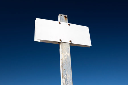 Blank white sign isolated on dramatic blue sky. Aged metallic post sign. Template Mock up