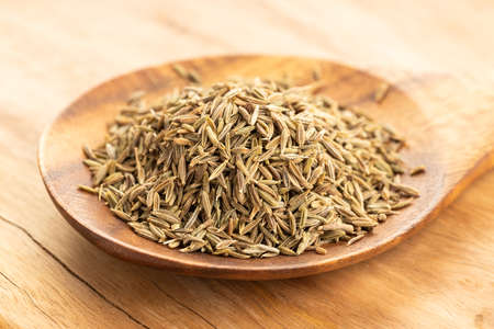 Cumin seeds on wooden spoon on table. Cuminum cyminumの写真素材