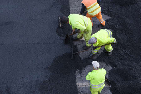 Workers during Asphalting Road Work on city street. Asphalt paving. High angle view. Copy spaceの写真素材