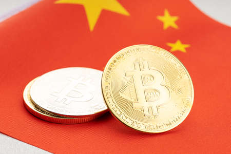 Bitcoin cryptocurrency coins on national flag of China. Crypto law regulation conceptの写真素材