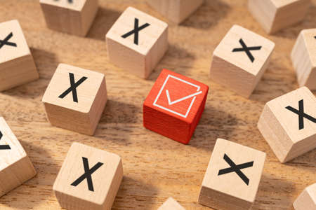 Right or good decision making concept. Check mark symbol and wrong or cross icon on wooden cubesの写真素材