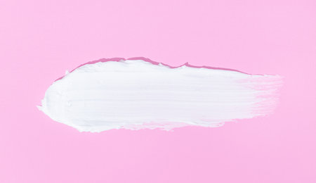 Face or body white cream smear isolated on pink backgroundの写真素材