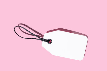 Blank white cardboard price tag isolated on pink background. Template mock up