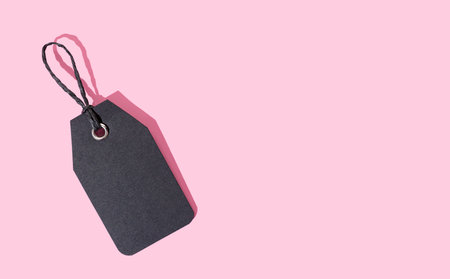 Template of black cardboard price tag isolated on pink background. Copy spaceの写真素材