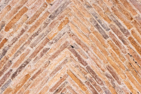 Background of old bricks laid in a herringbone pattern on a vault of a 17th century building. Full...