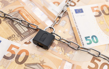 Lock security and chain on euro banknotes background. Monetary crisis, financial problems, sanctions, default conceptの写真素材