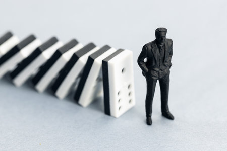 Domino effect concept. Dominoes falling and putting a company or investor at riskの写真素材