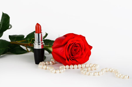 Roses, pearls and red lipstick on a light backgroundの写真素材