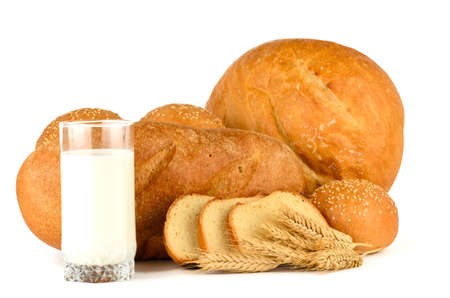 Bread, rolls with sesame seeds and a glass of milk on a white backgroundの写真素材