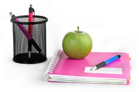 Three colored pens, notepads and green apple on a white backgroundの写真素材