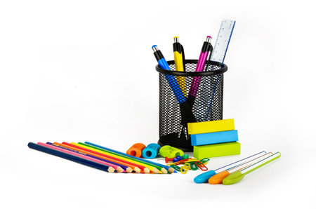 Colored pencils, pens, erasers, sharpeners on a white background