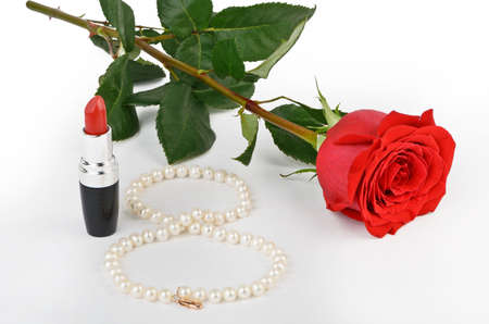 Roses, pearls and red lipstick on a light backgroundの写真素材