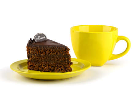 Chocolate cake on a yellow plate with a cupの写真素材