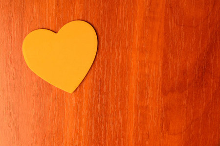 Orange heart on a wooden background