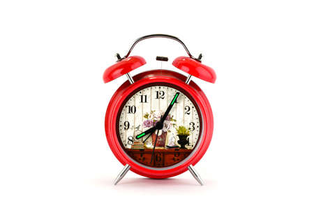 Red alarm clock with floral dial on a white backgroundの写真素材