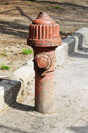Old, rusty red fire hydrant on the streetの写真素材