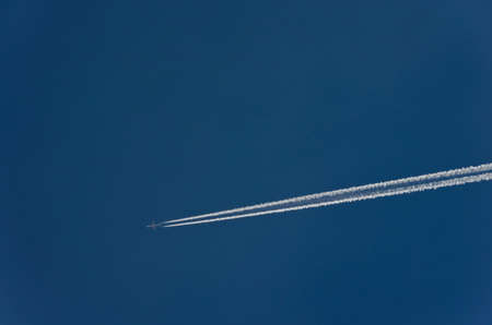 Aircraft condensation trails and in the deep blue skyの写真素材