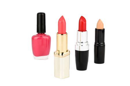 Three lipstick and a nail polish on a white backgroundの写真素材
