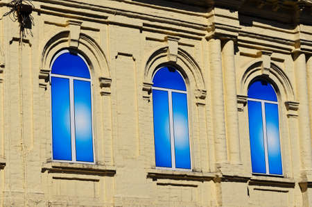 Three windows in the house on the streetの写真素材