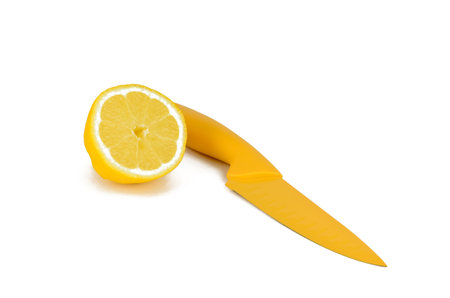 Half of lemon and yellow knife on a white backgroundの写真素材