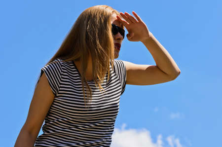 Young girl in sunglasses looks into the distanceの写真素材