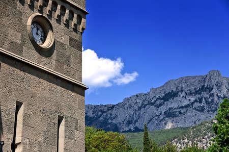 The clock tower on the background of the high mountainsの写真素材