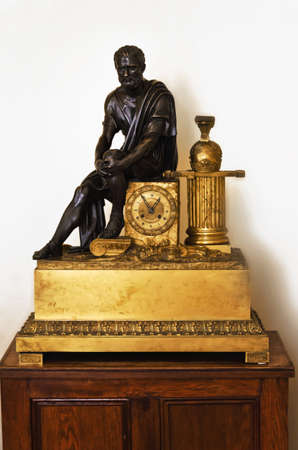 Gold antique clocks and black statue on a pedestalの写真素材