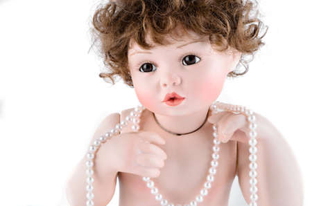 Porcelain doll with pearl beads closeup on white backgroundの写真素材