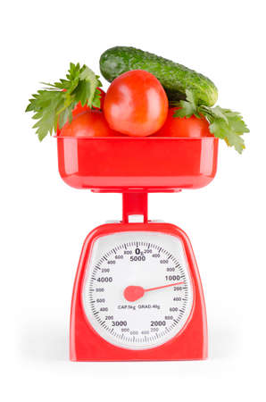 Fresh vegetables in a bowl of scales on a white background の写真素材