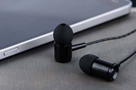 Headphones and phone closeup on gray background