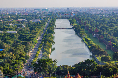 View over the moat of Mandalay Palace to Mandalay Hill with its many templesの写真素材