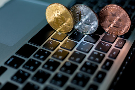 Coins of cryptocurrency or Bitcoin lying over laptop keyboard,  Business concept of worldwide cryptocurrency, Bitcoin trading concept, Laptop with Bitcoin, Cryptocurrency and banking concept.の写真素材