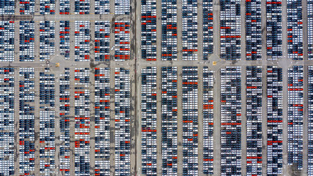 Row of new cars for sale in port at cars export terminal.