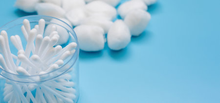 Plastic white cotton bud isolated on blue background, Plastic cotton swabs or cotton buds are on blue background, Plastic box with plastic white cotton bud with copy space.の写真素材