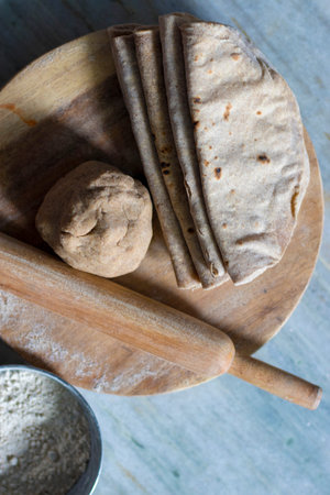 Bread and rolling pin on a wooden board with flour, top view