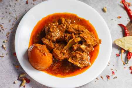 selective focus of delicious Indian style mutton curry with a decorative background.