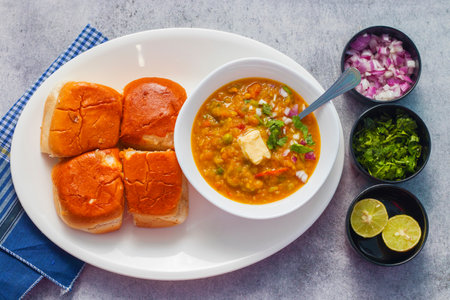 Lentil soup in a white bowl with bread and onions.の写真素材