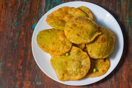 Crispy potato pancakes with green peas in white plate on wooden backgroundの写真素材