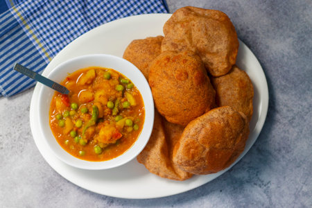 Indian masala curry with bread and green peas on a light background