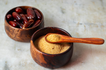 Dried dates in wooden bowl and spoonle background. Selective focus.の写真素材