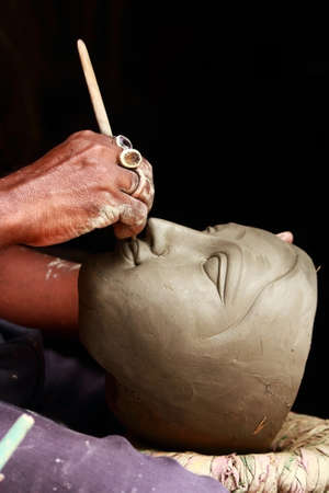 CALCUTTA - August 15: An artisan creates clay head of goddess Durga on August 15, 2011 in Kumartuli, Calcutta, India. The idols are made for the Hindu festival of Durga Puja also known as Dasseraのeditorial素材