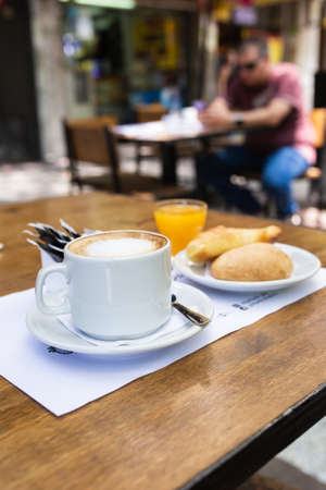 coffee with milk with orange juice and croissantsの写真素材