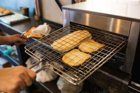 electric oven cooking ham and cheese sandwichesの写真素材