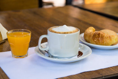 coffee with milk, orange juice and croissants