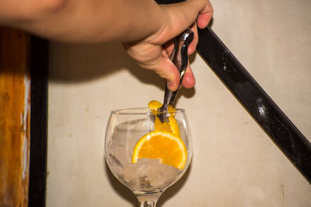person placing orange slices in a glassの写真素材