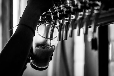 person serving beer in a glass, black and white