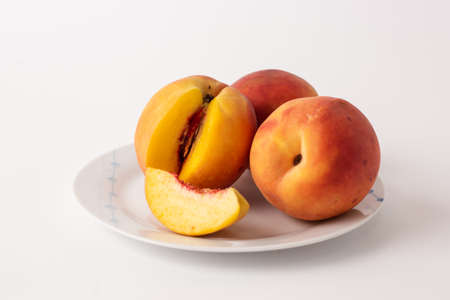 ripe peaches on a plate, white backgroundの写真素材